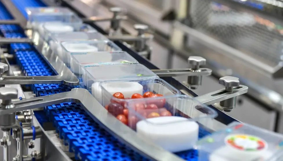 Frascos azuis percorrendo esteira de produção
